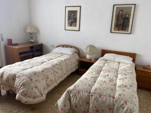LipomoVillino Carla的一间卧室配有两张床、一张桌子和两盏灯。