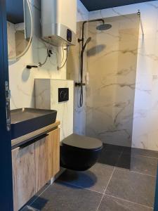 亚霍里纳Olympic Oasis的一间带黑色卫生间和淋浴的浴室