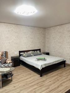 扎波罗热Apartment - Sobornyi Prospekt 97的一间卧室配有一张大床和一张桌子