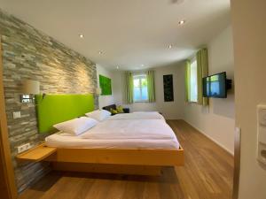 普莱因费尔德民俗乡间旅馆的一间卧室设有一张大床和绿色的墙壁