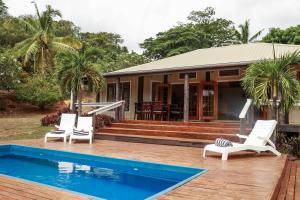 马洛洛莱莱Villa Oasis - PARADISE - MALOLO LAILAI - FIJI的一座带两把椅子的房子和一个游泳池