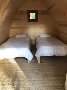格罗韦Camping & Glamping Muiñeira的配有窗户的小木屋内的两张床