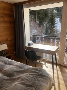 Laax-MurschetgLaax Flims Luxury Large apartment near Rock Resort的一间卧室设有一张桌子和一个大窗户