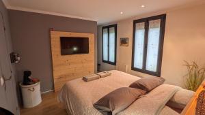 尚特洛普恩布里Chambres privées proche DISNEY Parcs的一间卧室配有一张床和一台平面电视