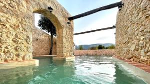 崔巴尔Hotel Village Balatura - exclusive VEGGIE的石墙内的水池