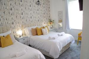 佩恩顿圣埃德蒙兹宾馆的一间卧室设有两张床和一张带照片的墙壁