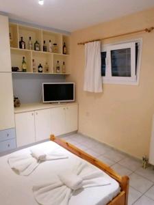 阿凯松Mavretas Apartments 3的卧室配有一张床铺,墙上配有电视