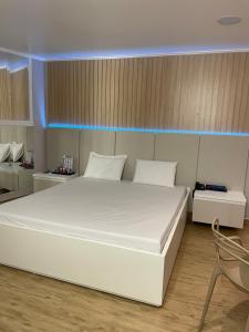 卡斯卡韦尔Motel Fascínio (Only Adults)的一张大白色的床,位于带椅子的房间