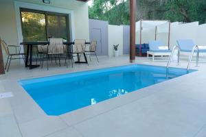 帕尔加Elite Luxury Villas的一个带桌椅的庭院内的游泳池