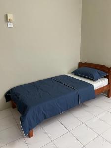 怡保To' Teh Homestay的卧室内的一张床铺,配有蓝色棉被