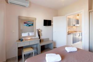 波利克罗诺Sueño beach hotel的客房设有一张床、一张书桌和一间厨房