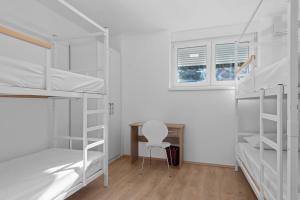 斯普利特Hostel Elli的客房设有双层床、书桌和椅子。