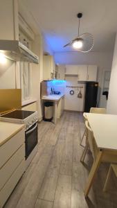 AlgrangeCocooning Logement entier [Parking Gratuit]的一间带白色橱柜的厨房和一间带桌子的厨房