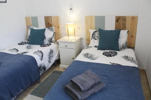 卡博皮诺BEACH FOREST PARADISE的一间卧室配有两张蓝色和白色的床