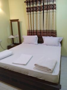 平纳瓦拉苏瓦尼皮纳维拉寄宿宾馆的一间卧室配有一张带白色毛巾的床