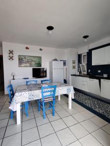 新福卡Villino sul mare的厨房配有桌椅和冰箱。