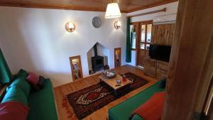 契拉勒Lycia Nature House的客厅设有绿色沙发和壁炉