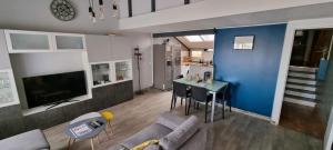 格吕桑Maison 3 pièces 5-7pers Vue sur port, garage, clim的带沙发和桌子的客厅以及厨房。