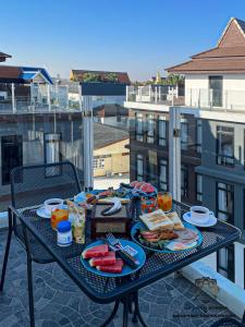 清迈DE LUXE BOUTIQUE & rooftop的阳台上的餐桌上摆放着食物