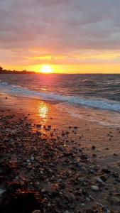 WangelsFerienwohnung Daliah的日落在海滩上与大海