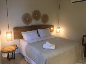 雅帕拉廷加Bangalos do Pontal的一间卧室配有一张床,上面有两条毛巾