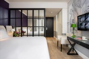 特拉维夫特拉维夫英迪格酒店 - 钻石区的卧室配有白色的床、书桌和床。