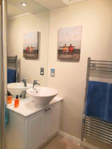 奥赫特拉德Willow Lodge Auchterarder的浴室设有两个水槽,墙上有两幅画作