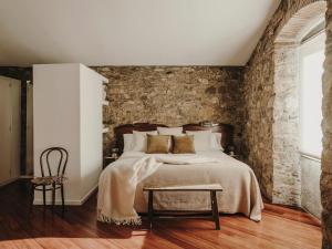 Llinars del VallèsParatgea的一间卧室设有一张床和砖墙