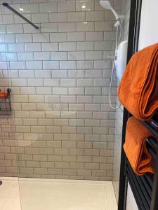 BeltonRuby’s Retreat的带淋浴和橙色毛巾的浴室