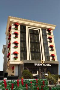 伊斯坦布尔Buem Hotel Koşuyolu的一座酒店大楼前方有红花