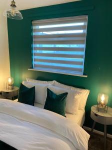 BeltonChester's Retreat的一间卧室配有一张白色的床和绿色的墙壁