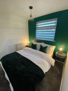 BeltonChester's Retreat的一间卧室设有一张大床和绿色的墙壁