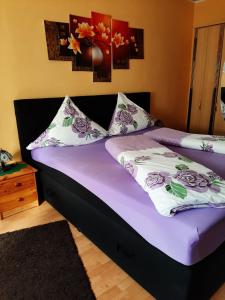 勒伯尔Ferienwohnung Röbel/Müritz的一间卧室配有一张带紫色床单和枕头的床。