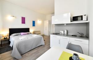 萨格勒布Deluxe Apartments Ria的一间带大床的卧室和一间厨房
