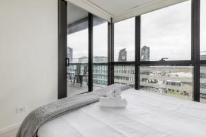 墨尔本KULA Docklands的一间卧室设有一张床和大窗户