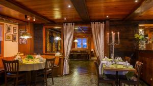 雷金根Swiss Lodge Joopi的一间设有桌椅的用餐室,拥有木制天花板