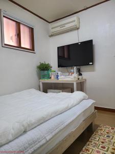 大邱Chenal Motel的一间卧室配有一张床和一台平面电视