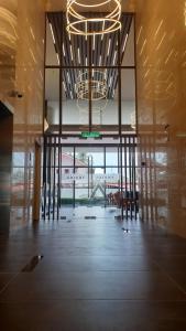 哥打巴鲁Prestige Troika Luxury Stay的一间设有吊灯、桌子和椅子的客房