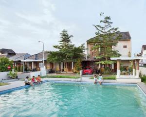 GondowulungOmah Rere Full 1 Rumah, 2 kamar AC的一群人坐在游泳池里