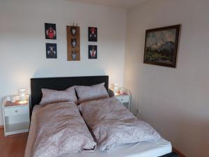 申瓦尔德Apartment 365 mit Sauna, Schwimmbad und Fitness的卧室内的一张床铺,墙上挂着照片