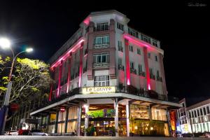 塔那那利佛卢浮宫酒店及spa中心的前面有粉红色灯的建筑