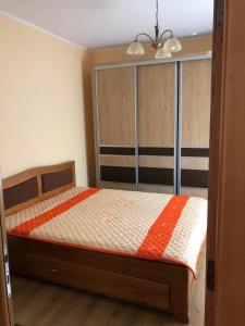 康斯坦察Casuta Lavi Constanta的一间卧室配有一张带橙色和白色棉被的床