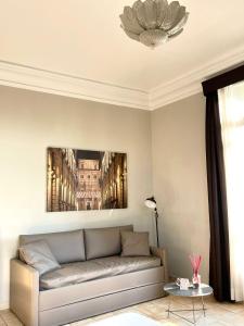 都灵Best Quality Hotel Dock Milano的客厅配有沙发和墙上的照片