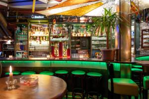 魏玛Pension Havana Club的酒吧设有绿色凳子和酒柜