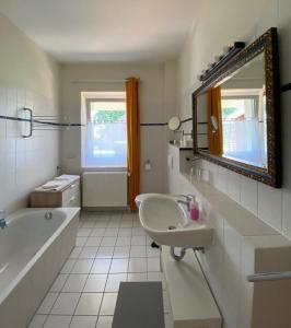 LansenRohrbruch的一间带水槽、浴缸和镜子的浴室