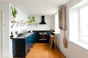 法尔茅斯Star & Garter的厨房配有蓝色橱柜和黑色台面