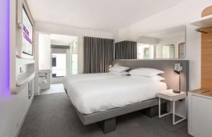 爱丁堡YOTEL Edinburgh的卧室配有一张白色大床和镜子
