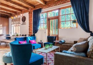 WydrzeRezydencja Julin Slow Life dla Gości 16+的客厅设有蓝色的椅子、桌子和窗户。