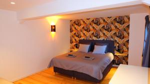 埃尔伯蒙La Tanière des Loups的卧室配有一张床铺,位于带墙壁的房间