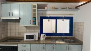 奥尔索拉Tranquilo y Acogedor Apartamento的厨房配有蓝色橱柜、水槽和微波炉